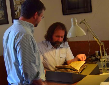 Scholar Grigory Kessel (seated) discusses a Syriac palimpsest.  